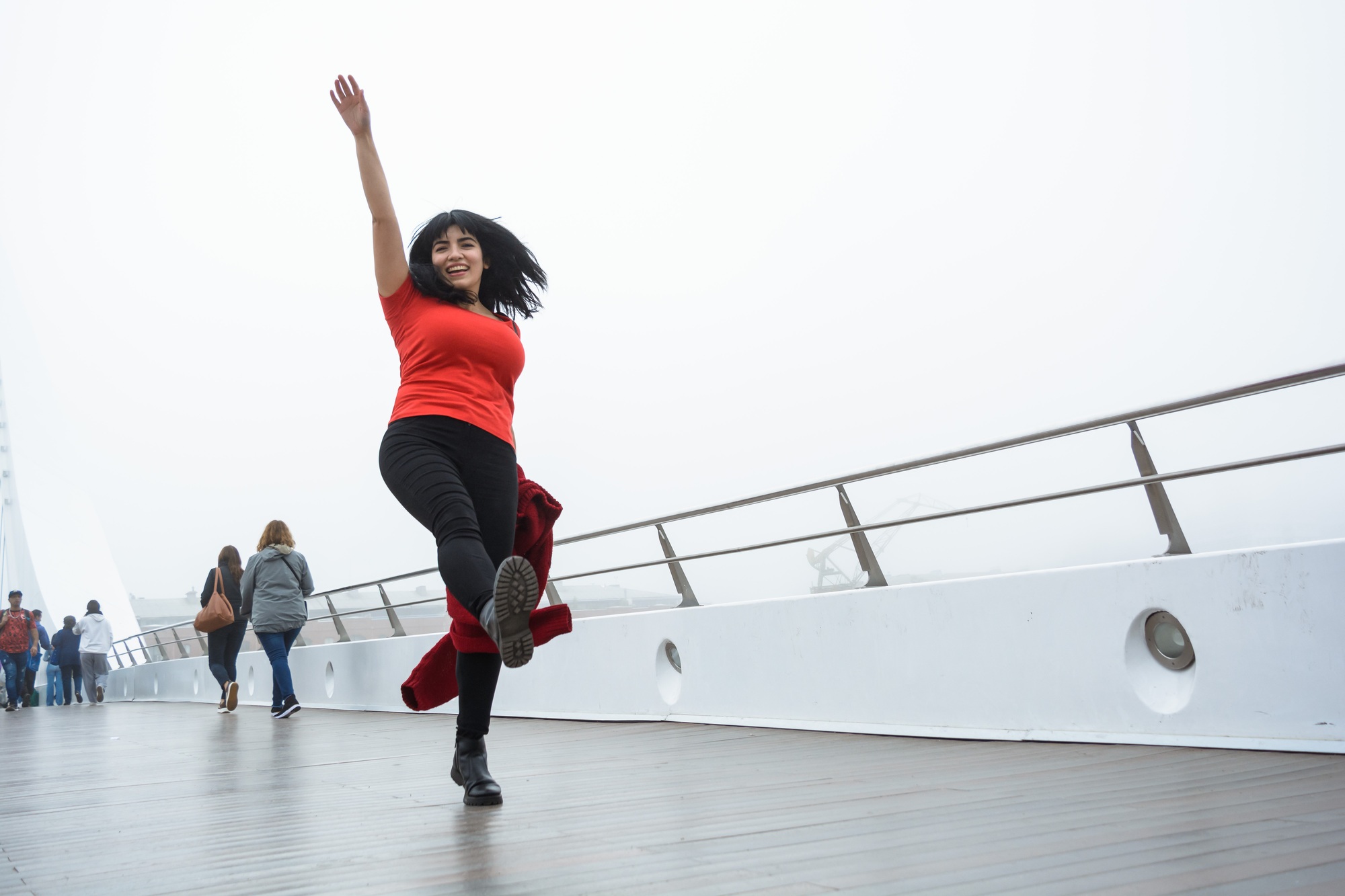 young tourist woman walking and jumping happily on the Puente De La Mujer in Buenos Aires.